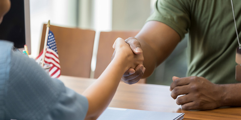 A soldier shakes a hand over a contract